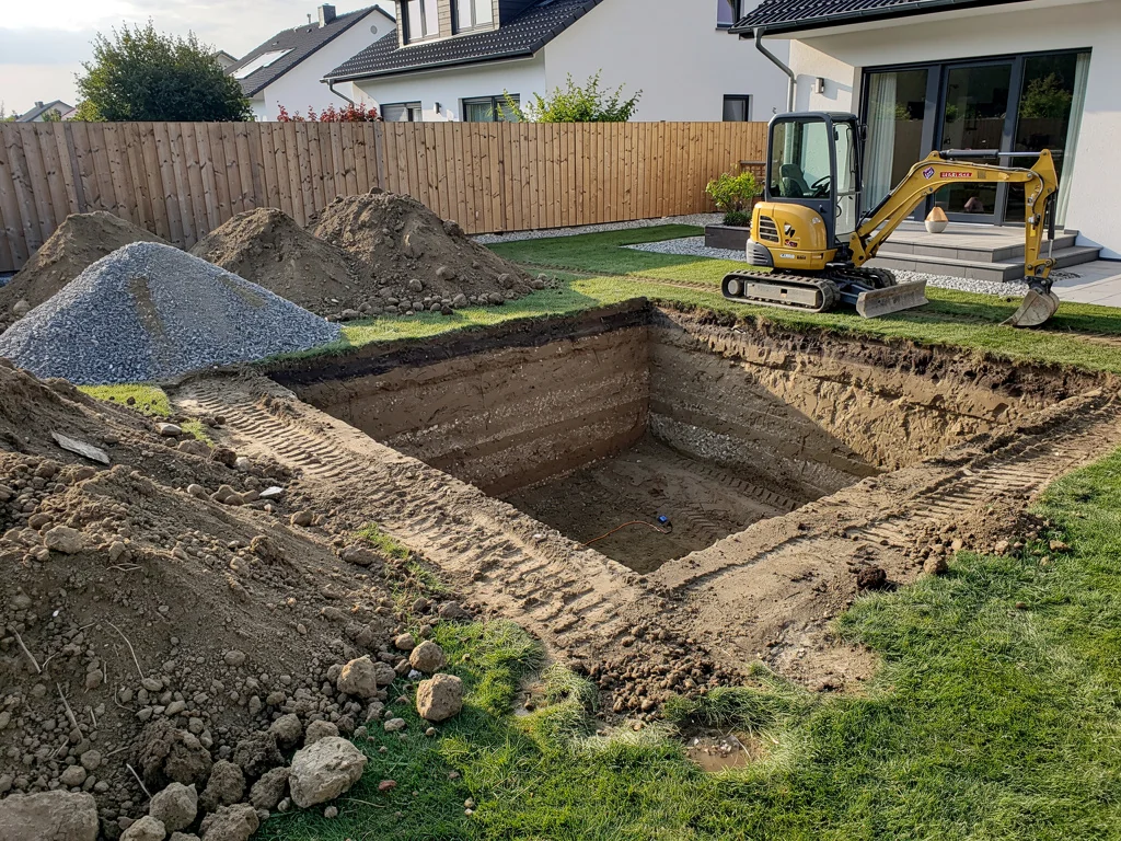 Chantier de terrassement pour la pose d'une piscine enterrée dans un jardin